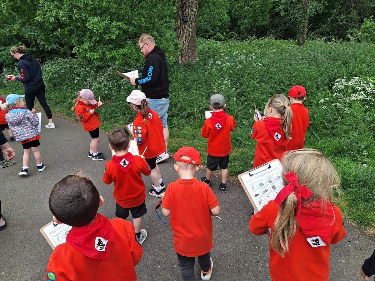 Squirrels on a nature trail with clipboards, guided by a leader
