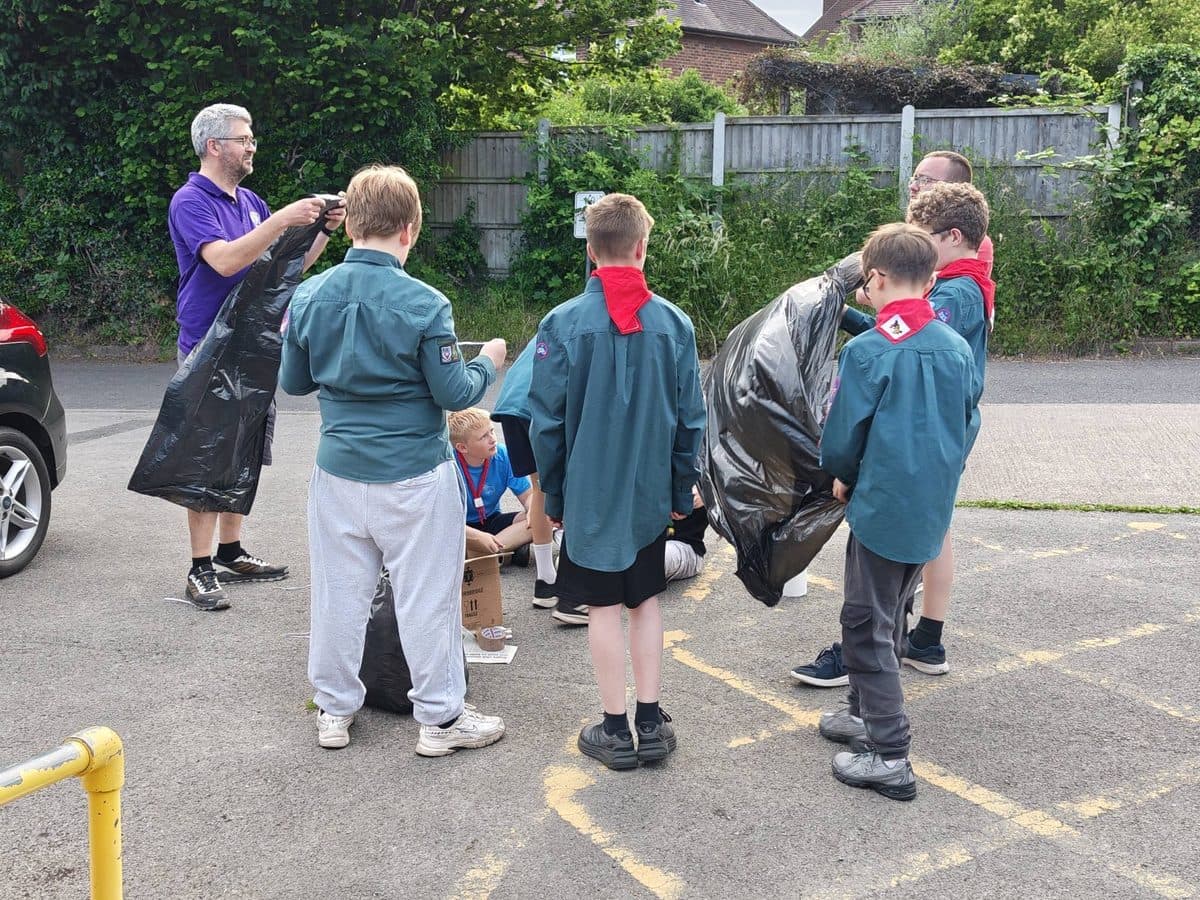 Scouts taking part in an outdoor team challenge with bin bags