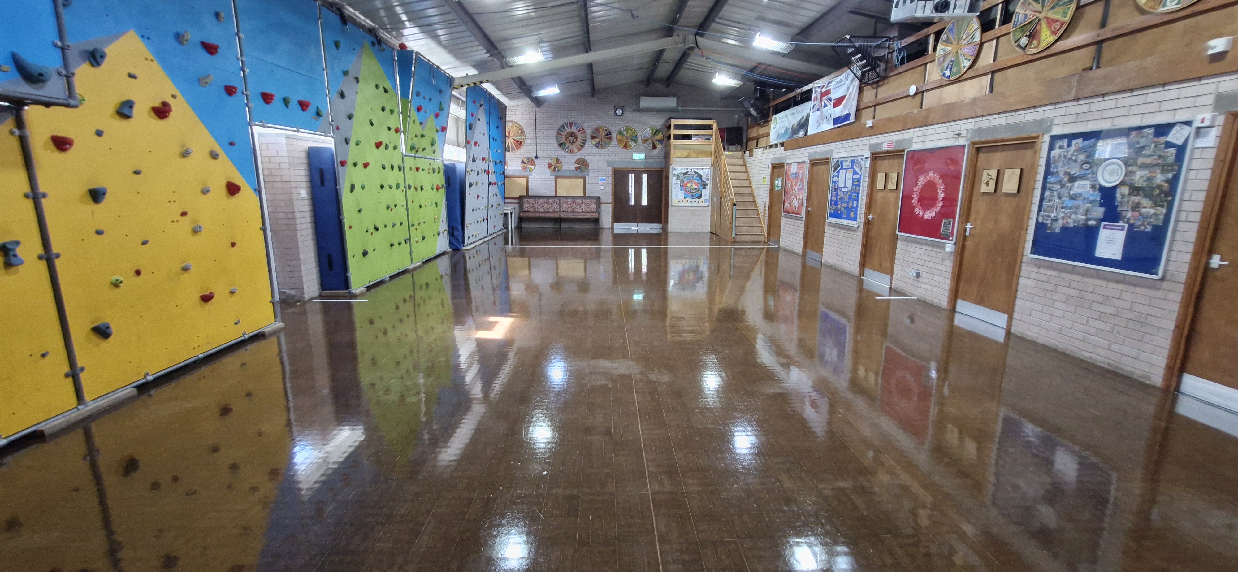The main hall — large open-plan space with polished floor and climbing wall