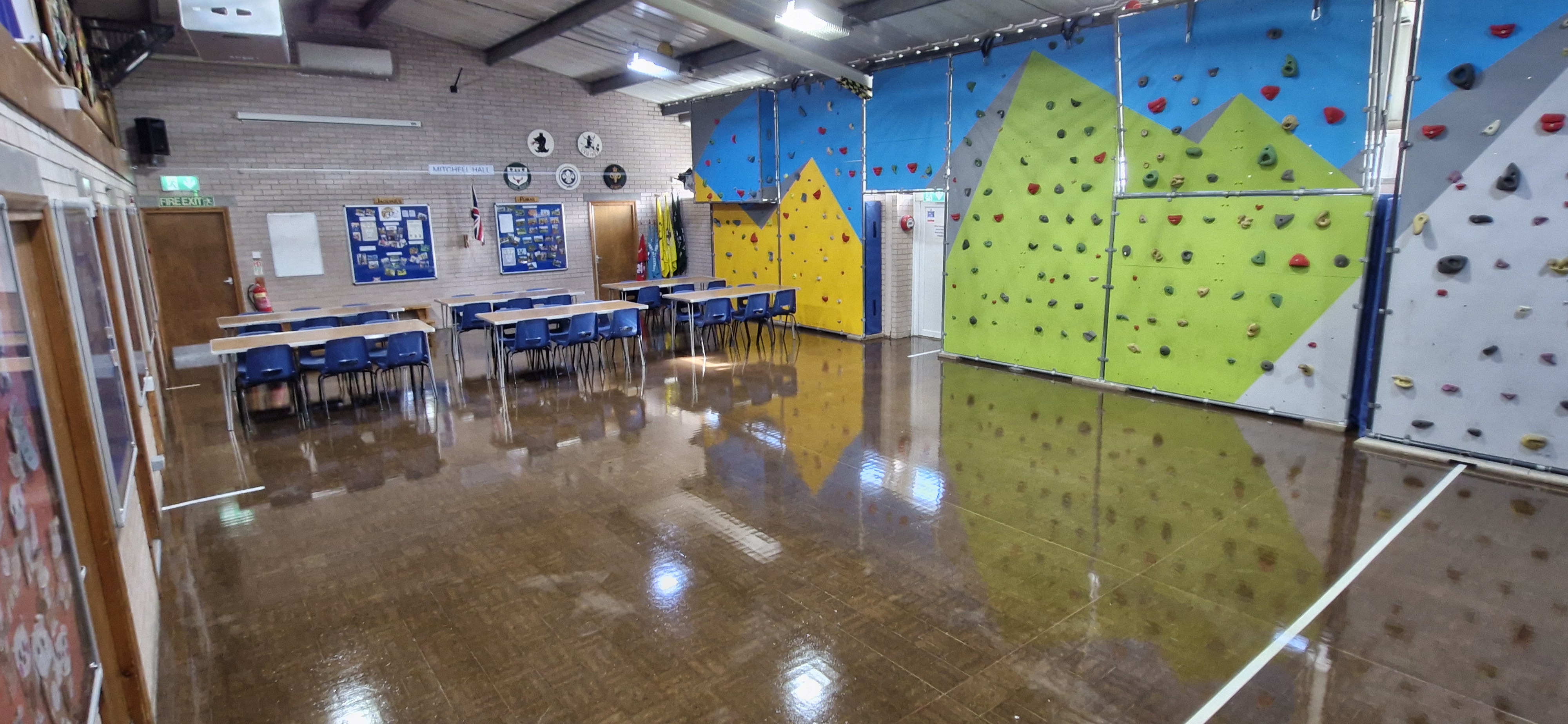 Hall set up with tables and chairs in a classroom layout